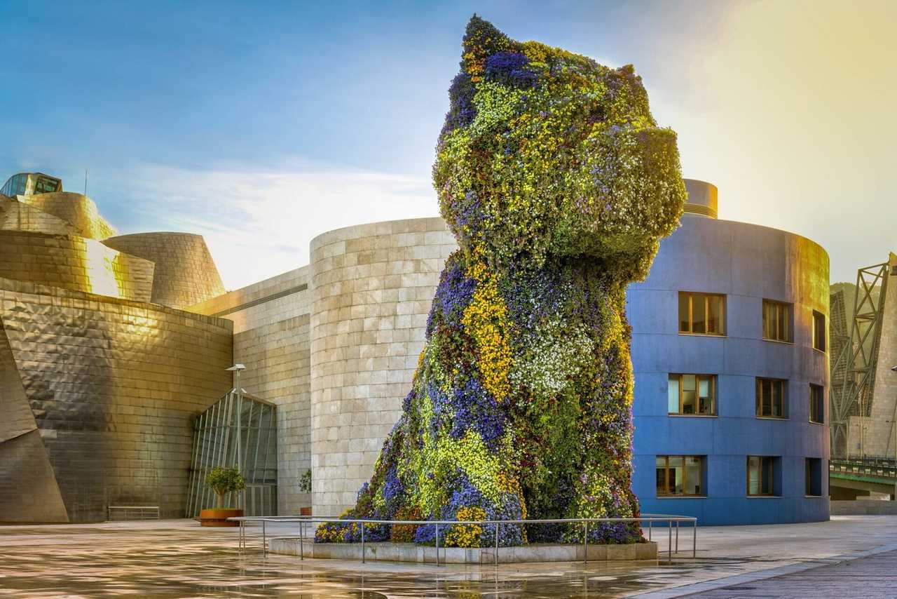Guggenheim Bilbao and Puppy topiary, day, pale blue sky