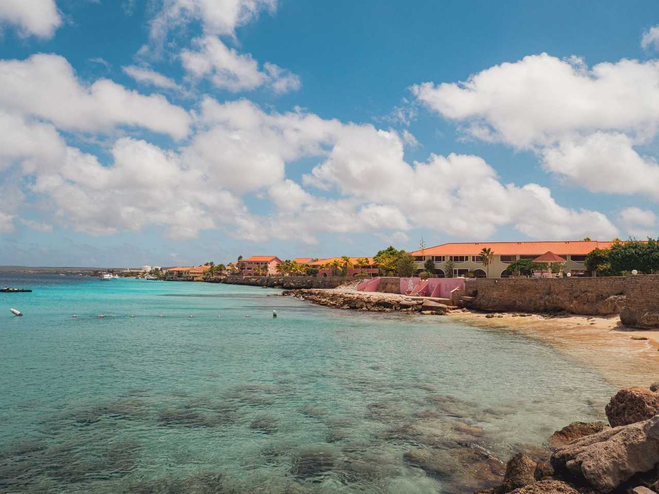 Bonaire shoreline with colourful waterfront buildings and turquoise water, day, blue sky