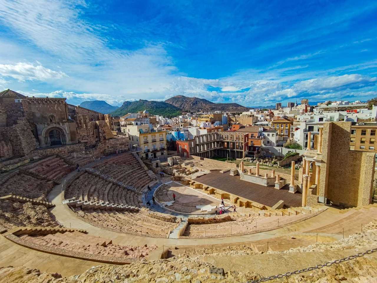 Roman Theatre of Cartagena with city behind, day, blue sky