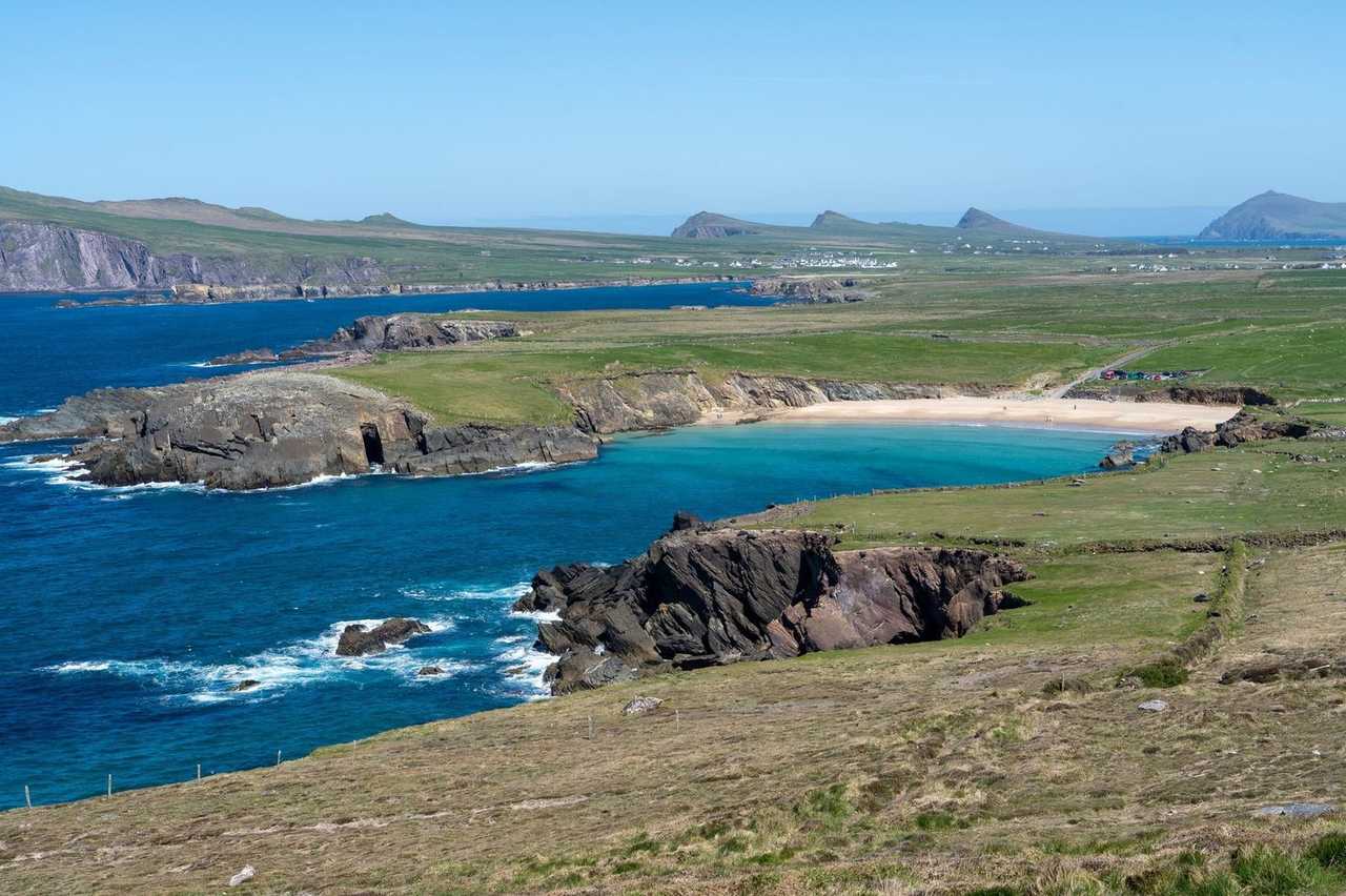 Slea Head / Dingle Peninsula cliffs and cove beach, day, solid blue sky