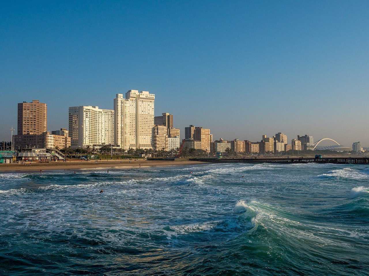 Durban Addington / Golden Mile beachfront with Moses Mabhida Stadium arch, day, pale blue sky