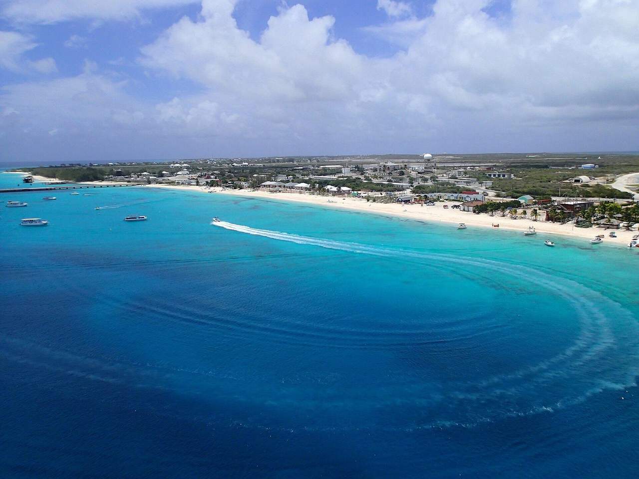 Grand Turk turquoise shallows and coastline with dome landmark, day, blue sky