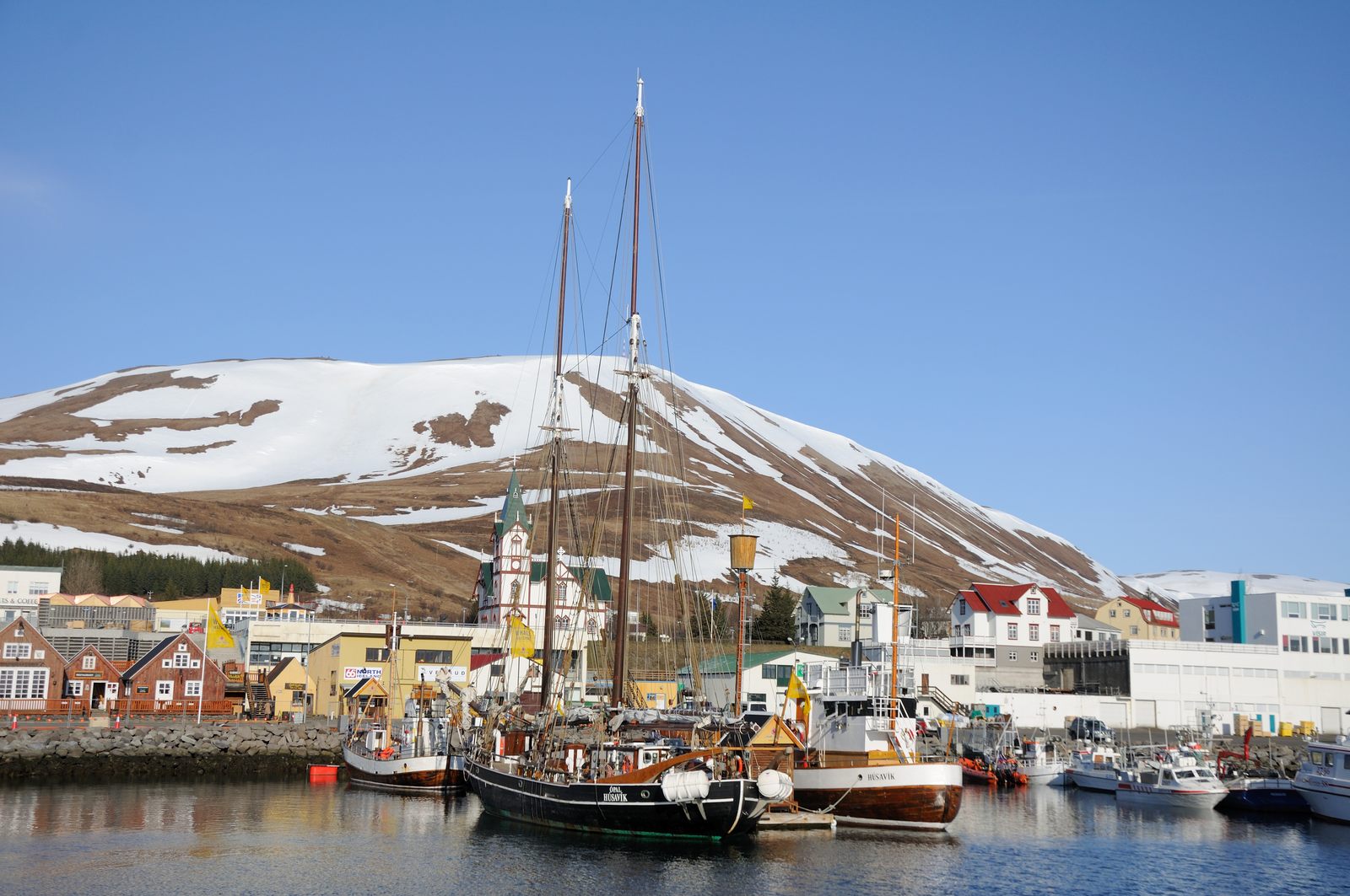 Húsavík harbour whale boats and wooden church on Skjálfandi Bay