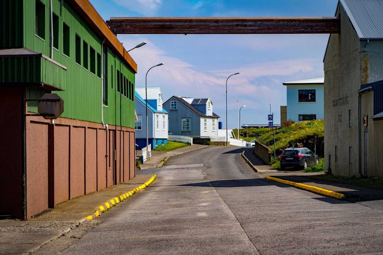 Ísafjörður street with Sjávarfangshús Icelandic signage and colourful houses, day, blue sky