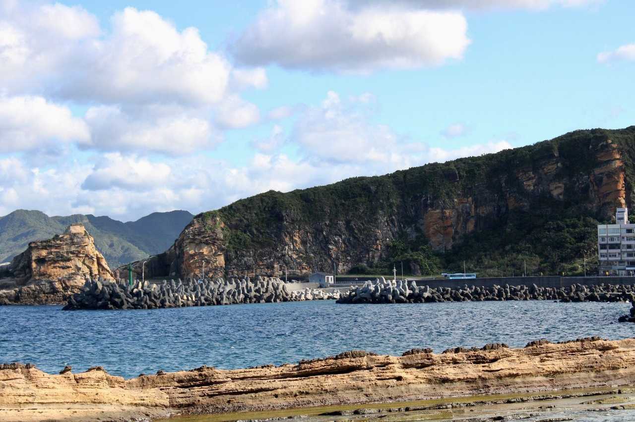 Keelung coastal sandstone platforms and vegetated cliffs under blue sky (Heping Island character)