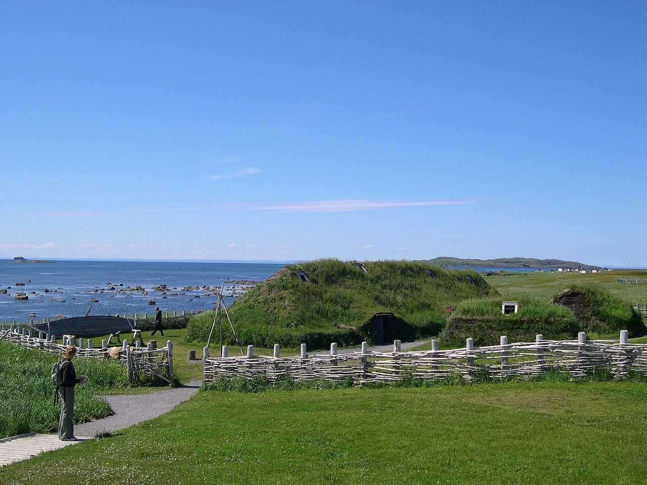 Reconstructed Norse sod houses at L'Anse aux Meadows, Newfoundland, day, solid blue sky