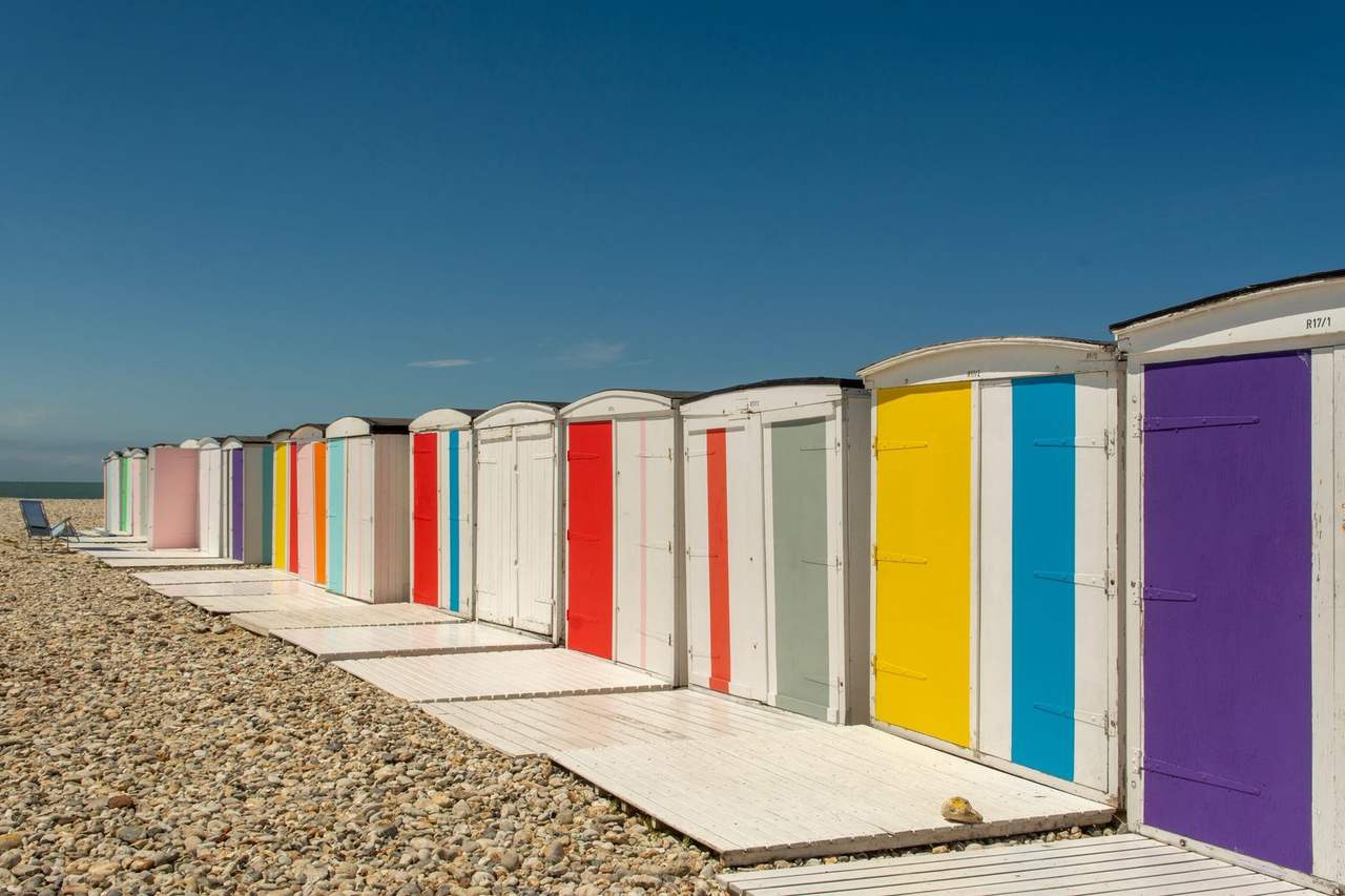 Colourful beach cabins on Le Havre / Sainte-Adresse pebble beach, day, solid blue sky