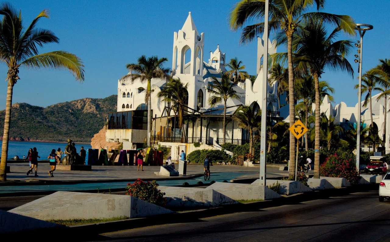Mazatlán malecón with Valentino's landmark and MAZATLAN letters, day, solid blue sky