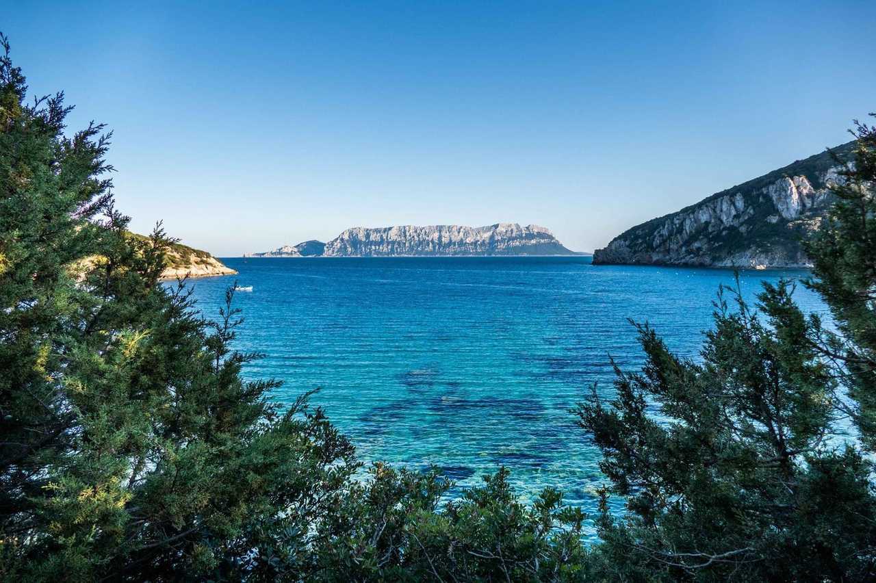 Tavolara Island limestone massif from Sardinia coast (Olbia), day, solid blue sky