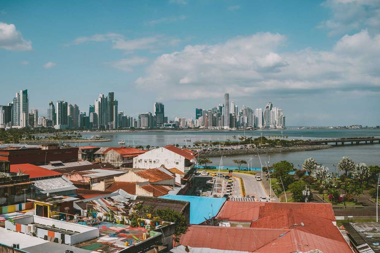 Casco Viejo rooftops toward Panama City modern skyline across the bay, day, blue sky with cumulus
