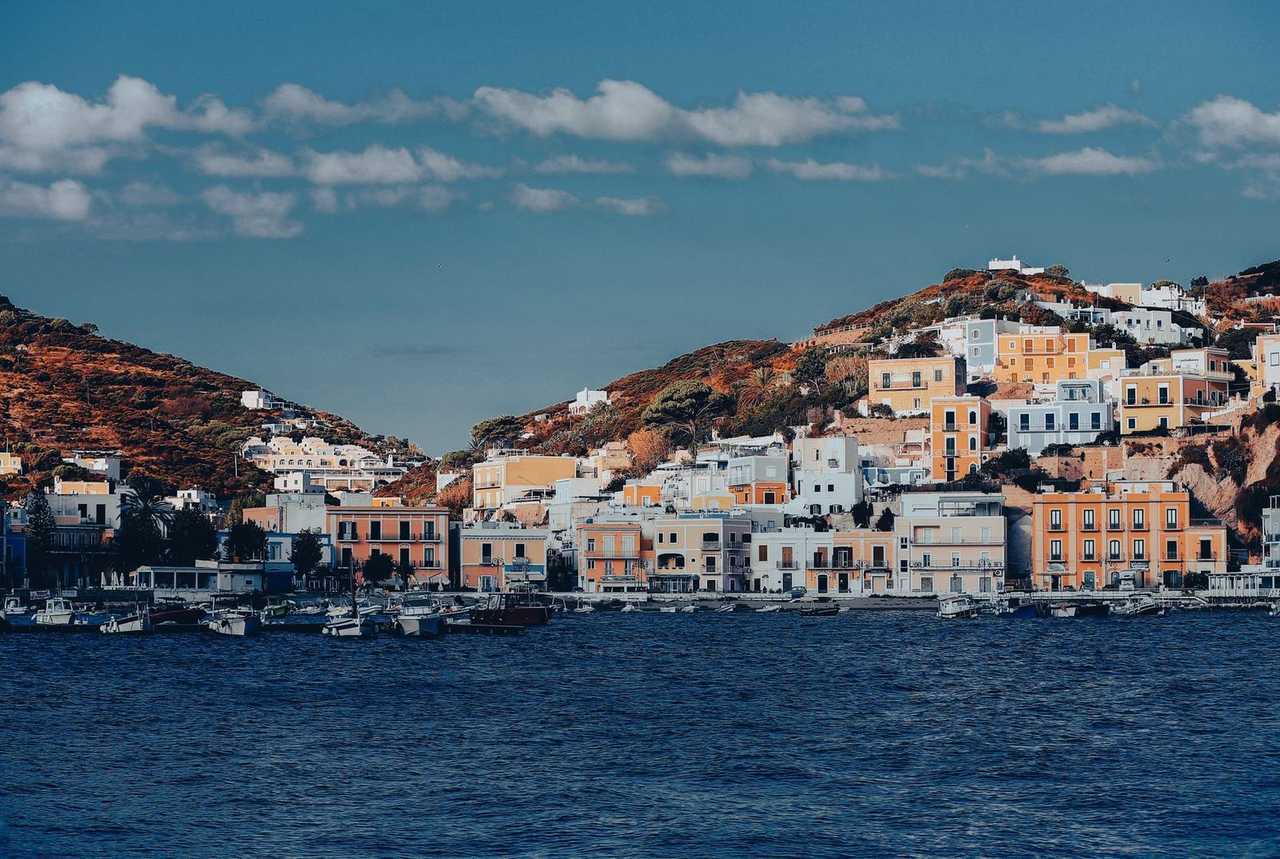 Ponza harbour colourful hillside houses over boats, day, blue sky