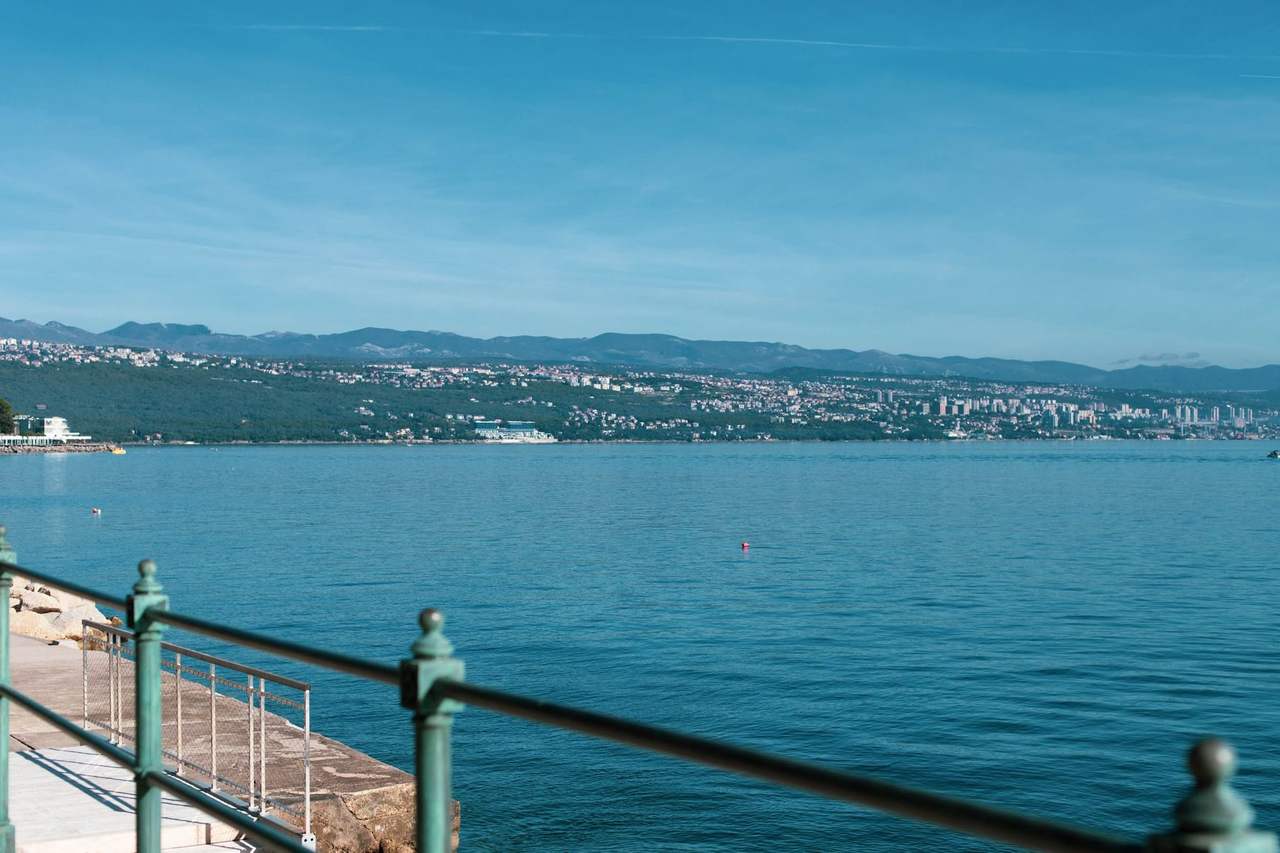Rijeka city across the Adriatic from Opatija coast, day, solid blue sky