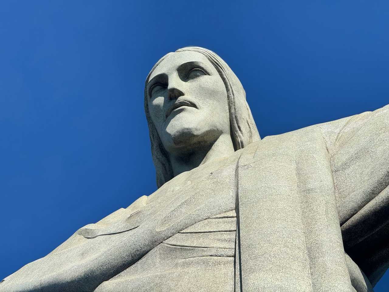 Christ the Redeemer soapstone mosaic close-up against solid blue sky, Rio