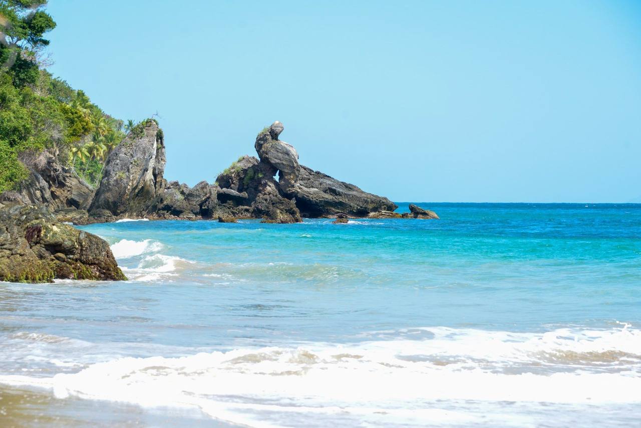 Samaná coast — distinctive arched sea-stack rocks and turquoise bay, day, clear blue sky