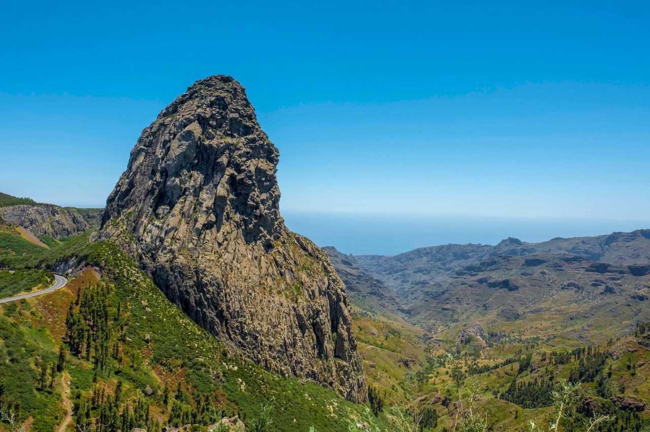 Roque de Agando volcanic plug, La Gomera (San Sebastián port), day, solid blue sky, valley to sea