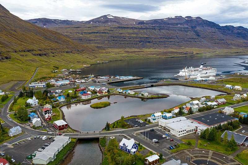 Coloured wooden houses and blue church at Seyðisfjörður on an east Iceland fjord