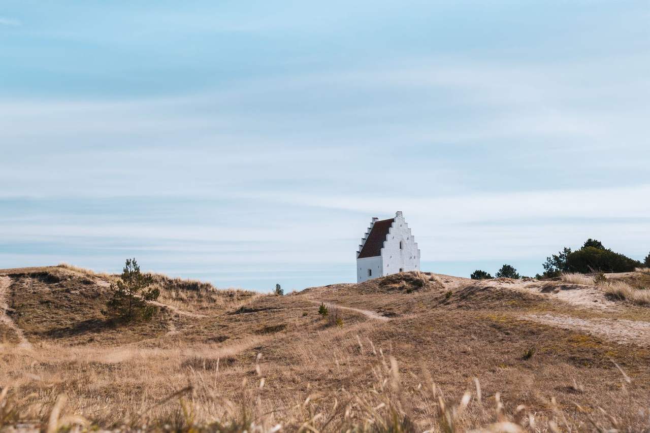 Den Tilsandede Kirke tower in Skagen dunes, day, pale blue sky