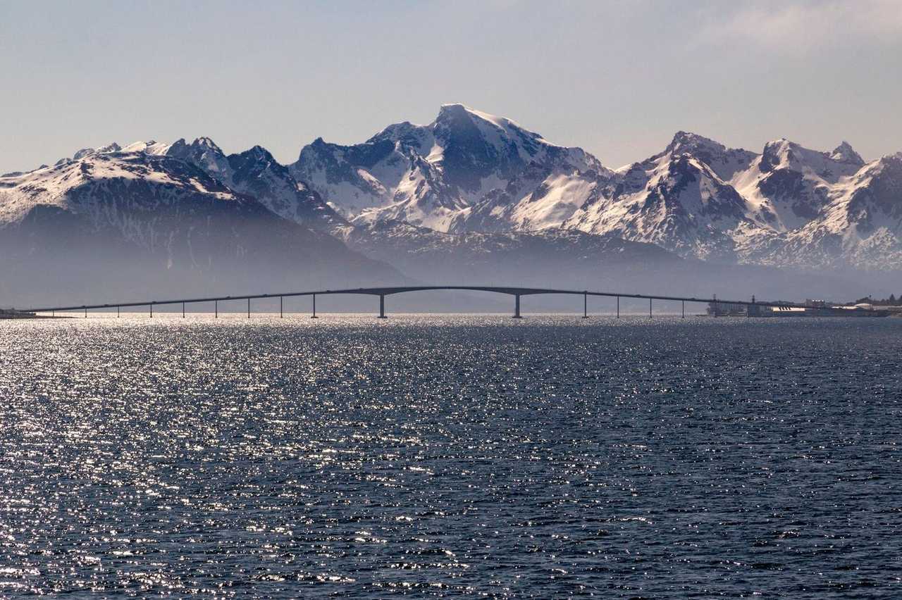 Sortlandssundet Bridge with snow mountains, Sortland Norway, day, pale blue sky
