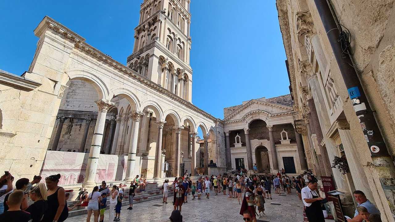 Peristyle of Diocletian's Palace with Cathedral of Saint Domnius bell tower, Split, day, blue sky