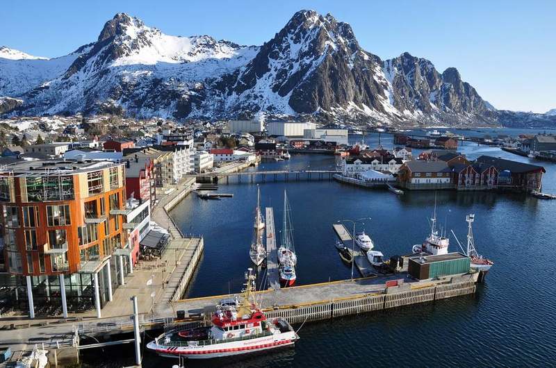 Red rorbuer waterfront under Lofoten peaks at Svolvær