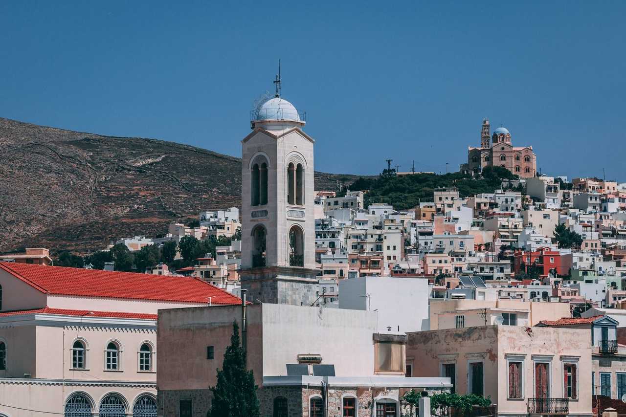 Ermoupoli hillside town and blue-domed church, Syros, day, solid blue sky