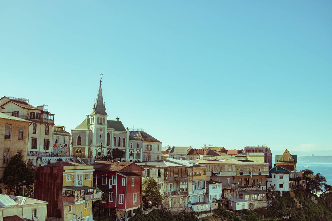 Valparaíso colourful cerros and Lutheran church spire over the bay, day, blue sky
