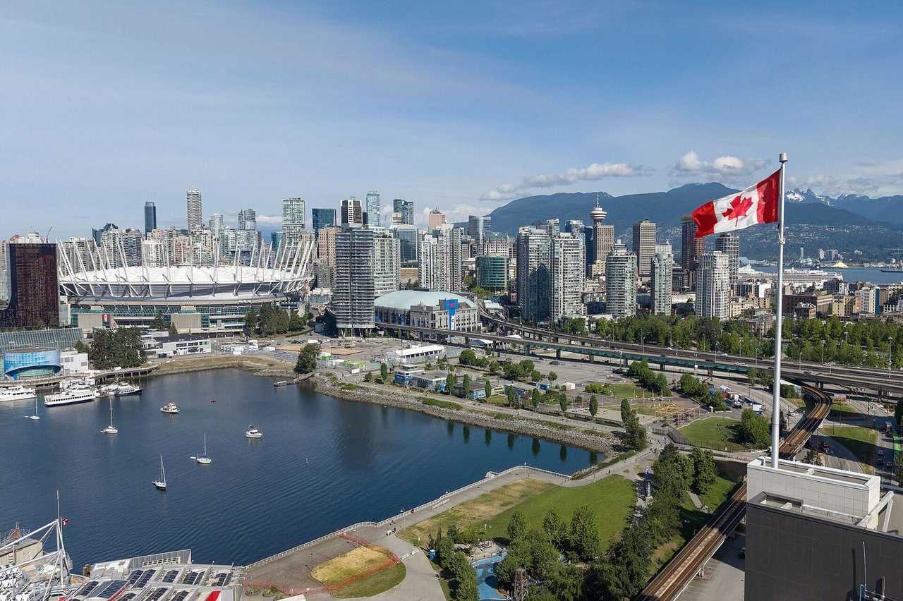 Downtown Vancouver / False Creek skyline, BC Place, North Shore mountains, day, blue sky