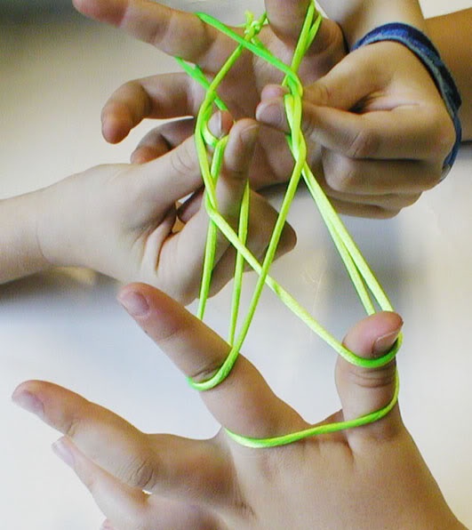 two people playing the string game cats cradle together