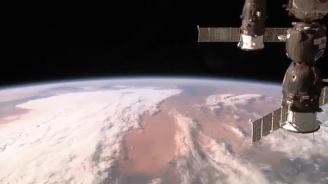 A name card sliding in at the top left over footage of a Dragon capsule at the space station, with captions below