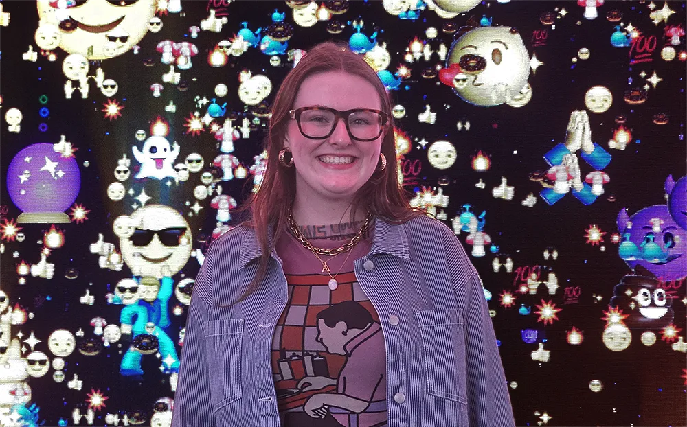Alex, in front of a wall of emoji