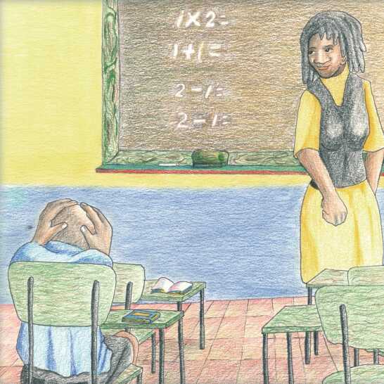 A boy holding his head, sitting at a desk in a classroom, and a teacher looking at him. 