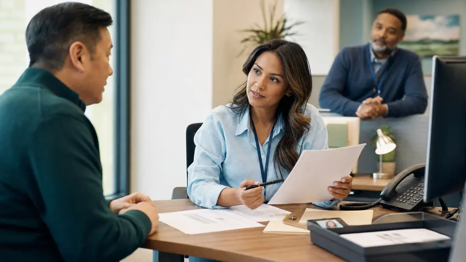 A member-services specialist helps a customer complete a coverage change with a supervisor available for escalation.