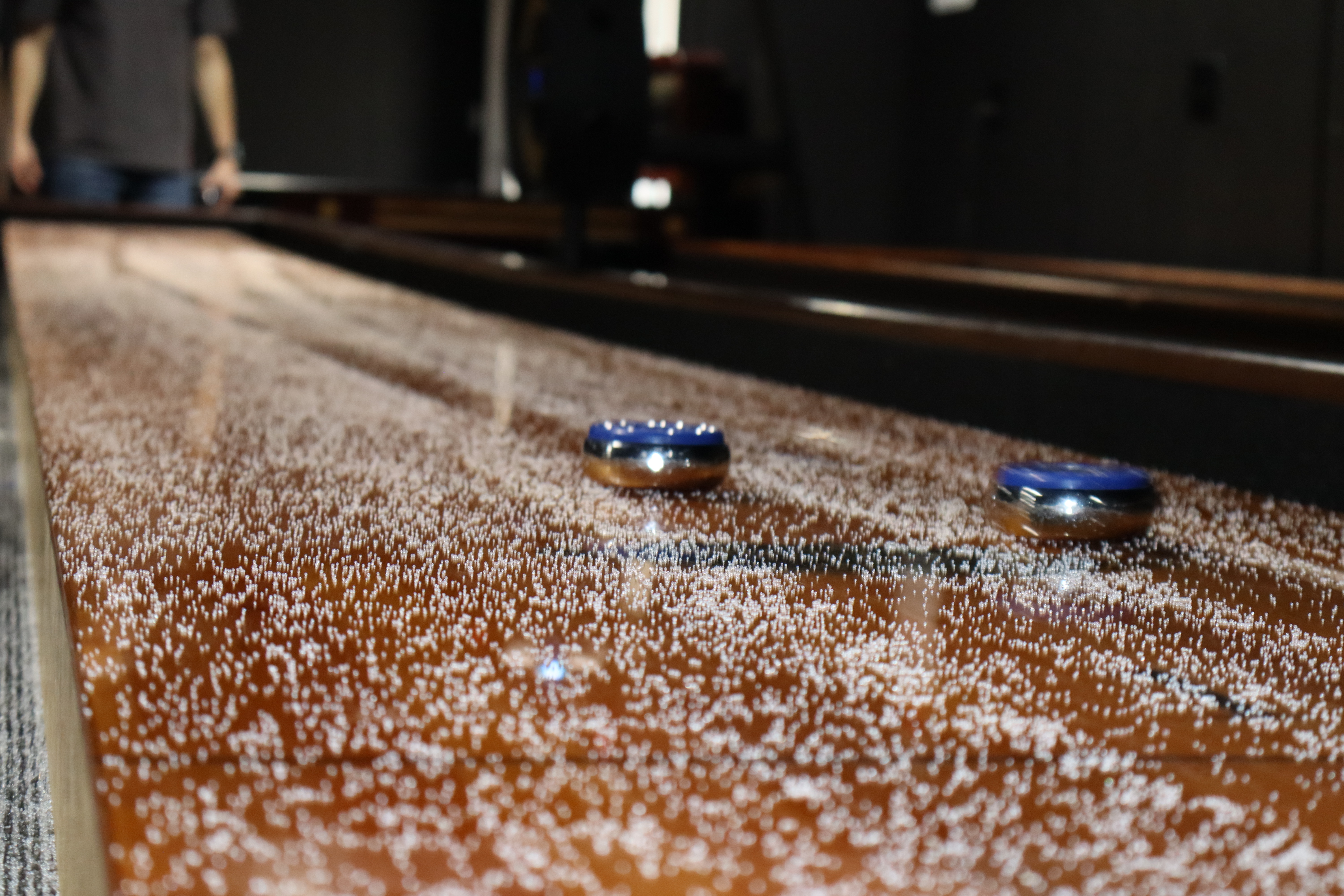 Shuffleboard pucks gliding on sand at PBR