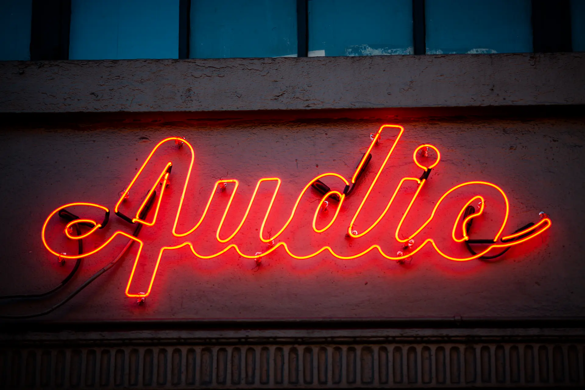 The word Audio written on a neon sign