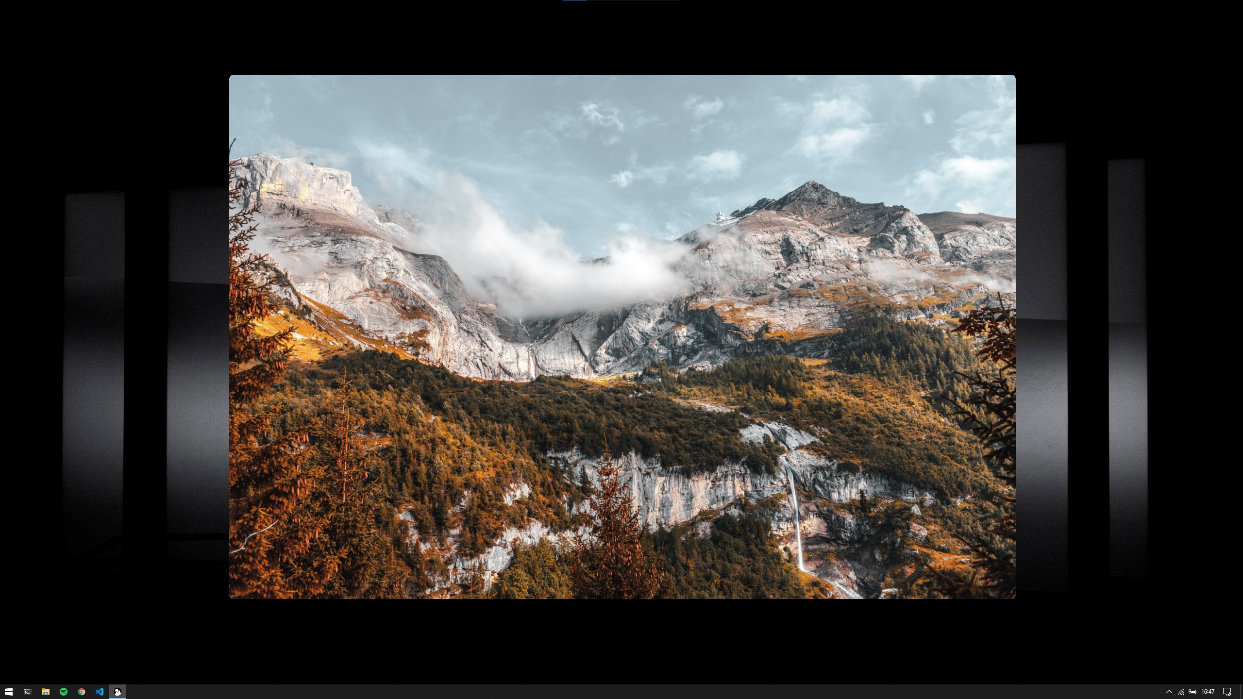 Shows a desktop with a window with curved corners and no border in the center displaying a mountain image.