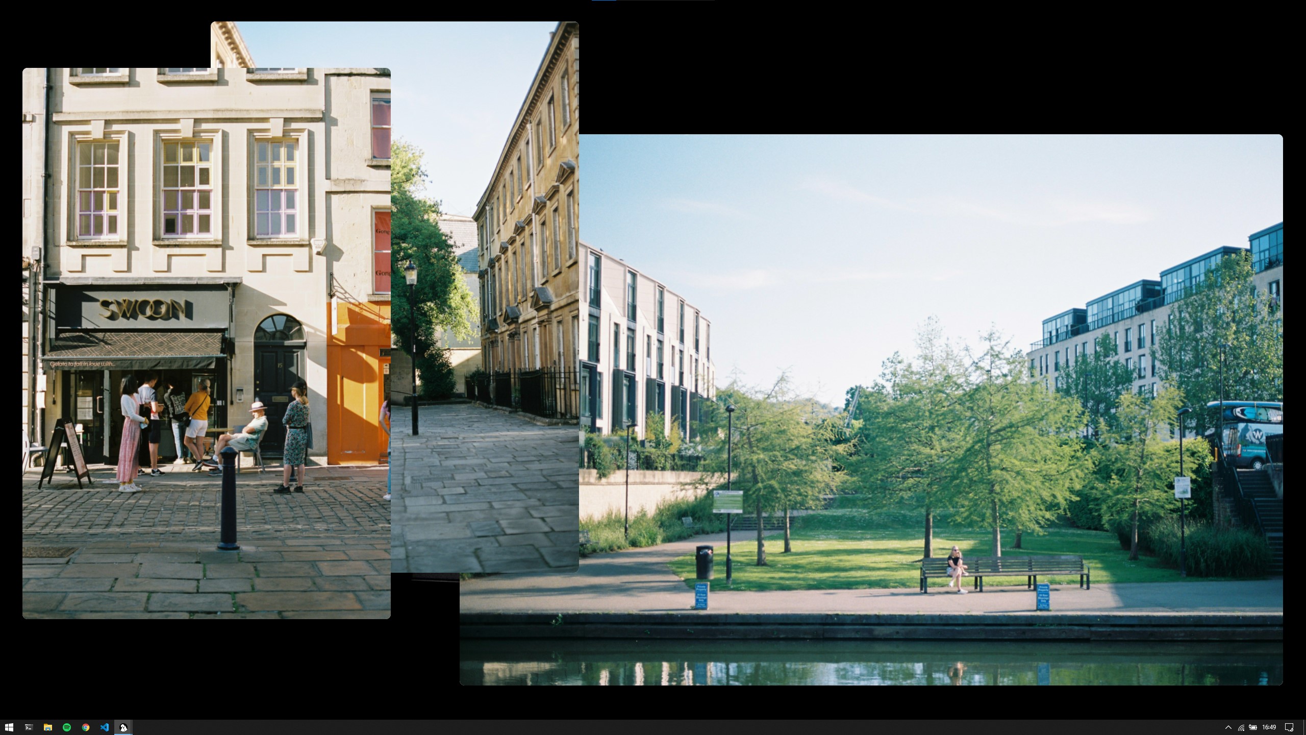 Shows a desktop with three windows all overlapping each other. One window contains a street scene with a small food business and people outside. The second presents a narrow street with a tree at the end of it. The last window holds an image of a riverbank with a park and buildings in the distance.