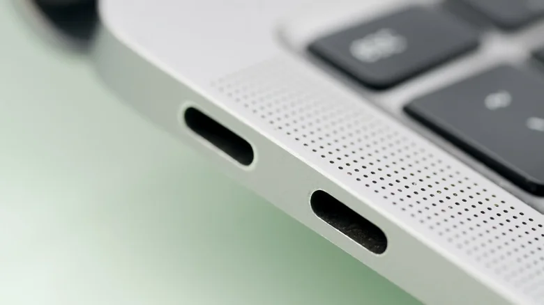 Close-up view of the side of a silver MacBook, showing two USB-C ports.