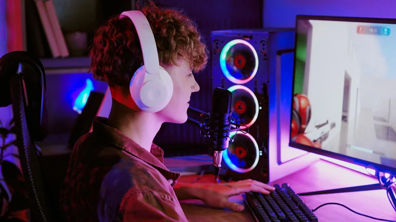 A gamer playing a first-person shooter on a souped-up desktop PC.