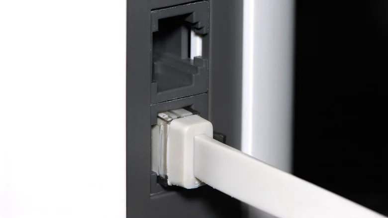 A flat Ethernet cable plugged into a mesh Wi-Fi router.