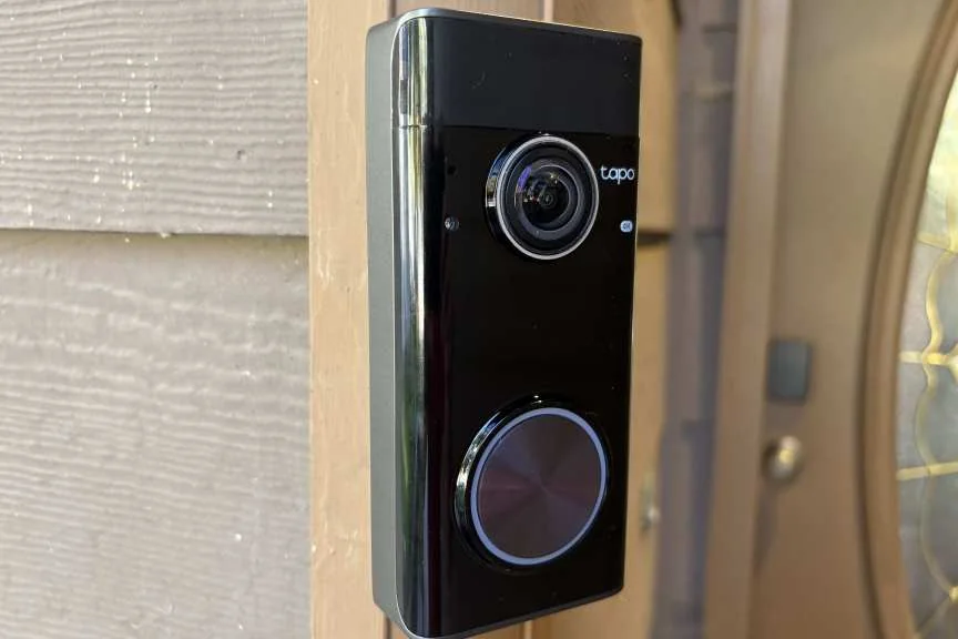 Tapo's 4K doorbell on a wood trim.