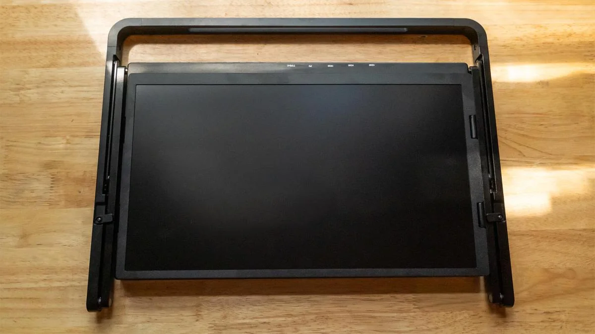 The Aura Triple 15.6" Aero Pro Max folded on a wood desk.
