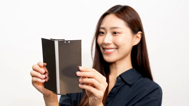 Woman holding a partially folded flexible display panel.