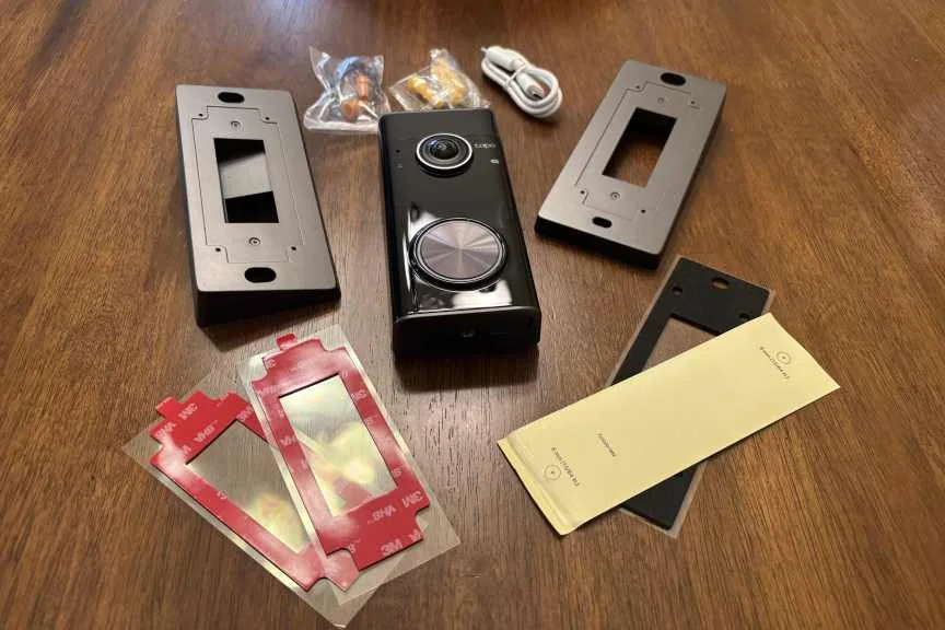 Tapo doorbell kit laid out on wood table.