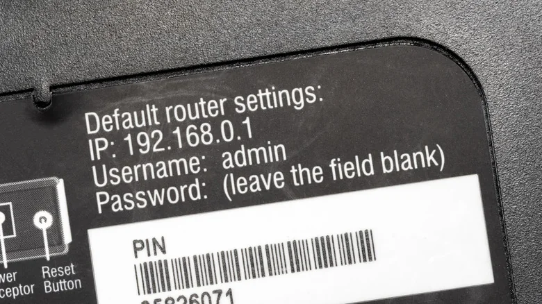 Close-up of underside of router, with a label showing default router admin credentials.