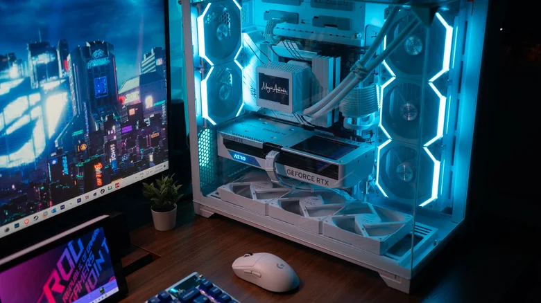 Desktop gaming PC and monitor on a desk with a mouse, keyboard and tablet.