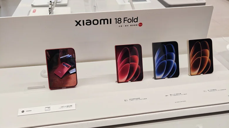 The Xiaomi 18 Fold, shown in various colors on a store display table.