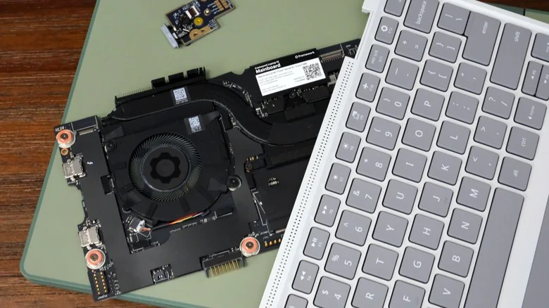 Framework Laptop 12 on a table, on top of which is its mainboard, fingerprint reader and input cover.