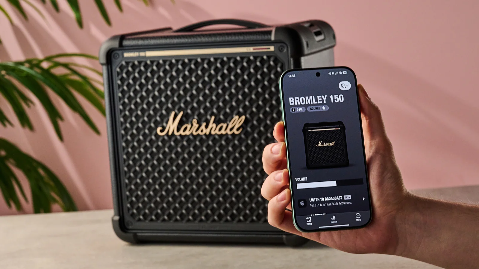 Man holding phone with Marshall Bluetooth app in front of the Marshall Bromley 150