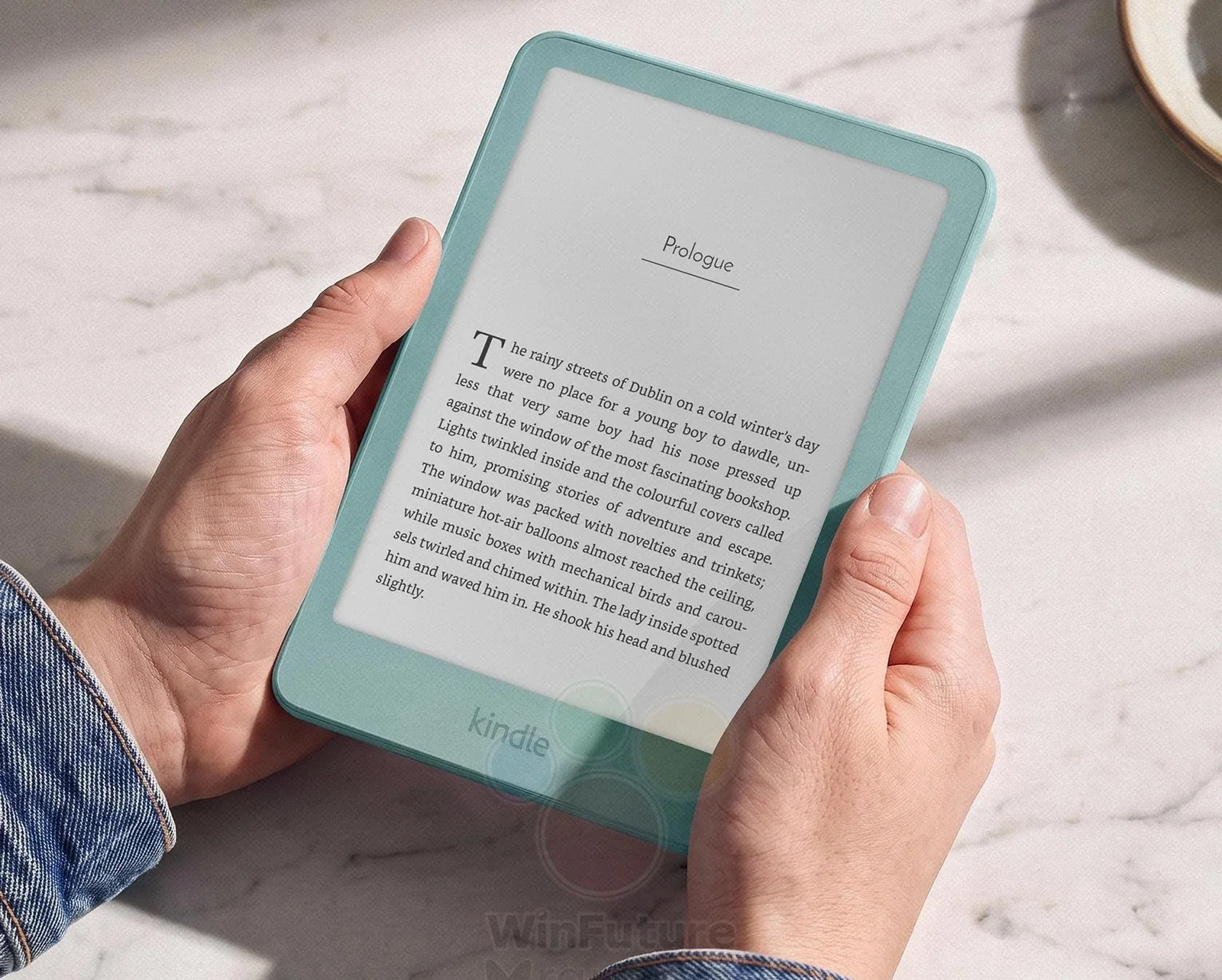 A person holds an Amazon Kindle e-reader in two hands.