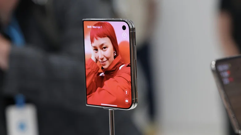 The iPhone Duo's outer display showing a person on the wallpaper, plus various controls.